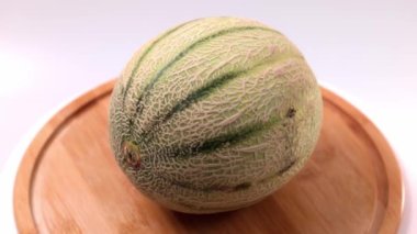 View of Cantaloupe melon on wooden cutting board isolated