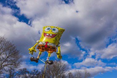 Beautiful view of holiday foldable sponge Bob figure on blue sky and white clouds background. Sweden. Uppsala. 04.19.2022.