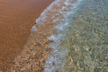 Beautiful view of coast sea with rolling wave on sandy beach. Greece.