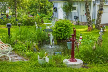 Beautiful view of private garden with decorative pond, fountain and landscaping. Sweden.