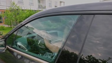 Close up view of woman leaving the parking lot of private house in electric car. Sweden.