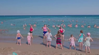 Close up view of tourists exercising in water with group of hotel sport instructors. Rhodes. Greece. 07.15.2022. 