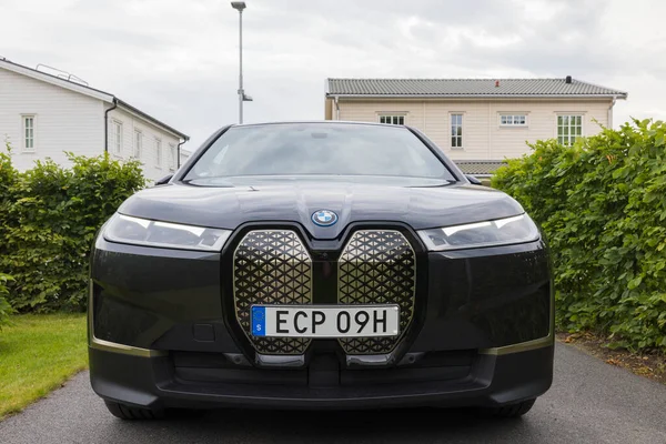 Close up view of new BMW IX40 electric car in villa's private parking lot on cloudy summer day. Sweden. 08.18.2022.