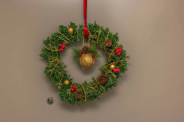 Close up view of Christmas wreath of spruce branches hanging on apartment front door. Sweden.