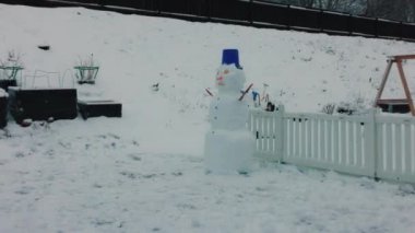 Beautiful view of snowman made by children in winter garden. Sweden.