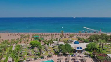 Beautiful top view of beach in Mediterranean sea and hotel area with outdoor pool. Greece. Rhodes. 08.25.2022.