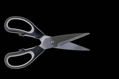 Close up view of kitchen scissors isolated on black background. 