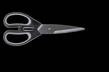 Close up macro view of kitchen scissors isolated on black background. 