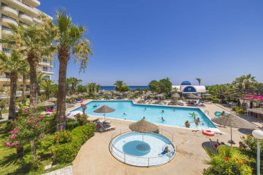 Beautiful view of empty outdoor pool with sun umbrella in middle for babies. Greece. Rhodes. 08.09.2022