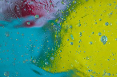 Soyut tasarımın su dokusunun kırmızı, mavi ve sarı tonlarını yakından incele.