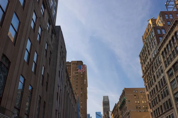 在纽约的摩天大楼之间 有着美国国旗的蓝天的美丽的底层景观 — 图库照片