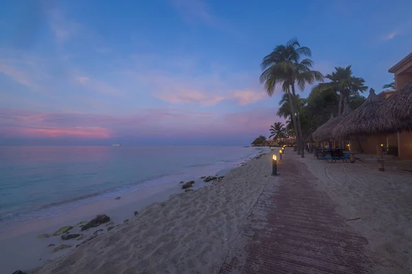 Amazing view of sunset with turquoise water Atlantic ocean on sand beach of Aruba Island.