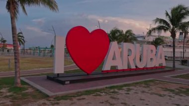 Aruba 'nın başkenti Oranjestad' ın merkezinde gün batımında Aruba 'yı seviyorum. Büyük kırmızı kalp sözcük sevgisinin yerini aldı. Aruba. Oranjestad. 09.09.2022.