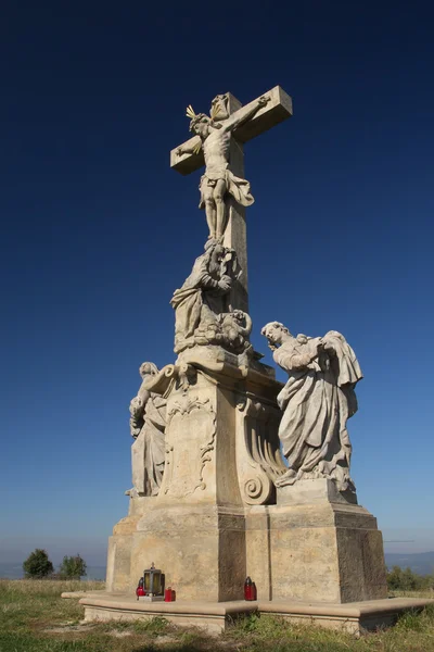 Socha Ježíše Krista na kříži. modrá obloha v pozadí. — Stock fotografie