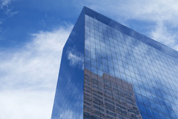 Modern skyscrapers with clouds reflection.