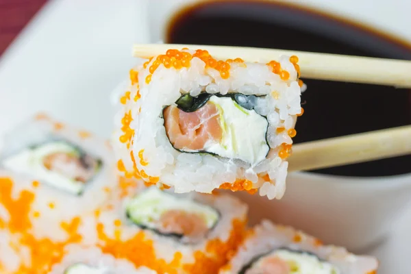 Um pedaço de sushi Maki em pauzinhos — Fotografia de Stock