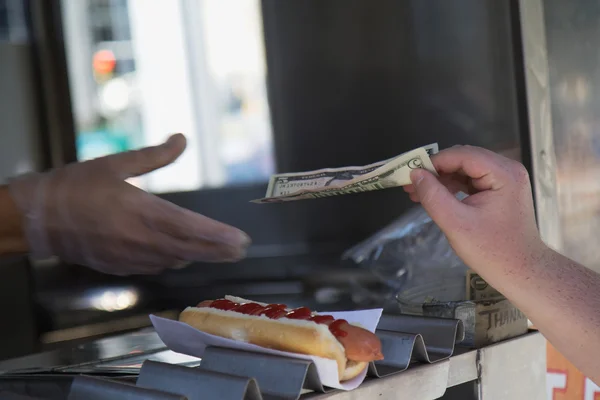 Betalen voor gekochte hotdog — Stockfoto