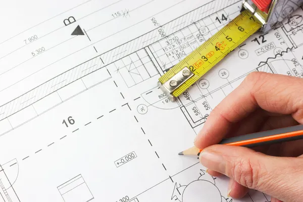 Plan of a house, ruler and a hand writing with a pencil — Stock Photo, Image