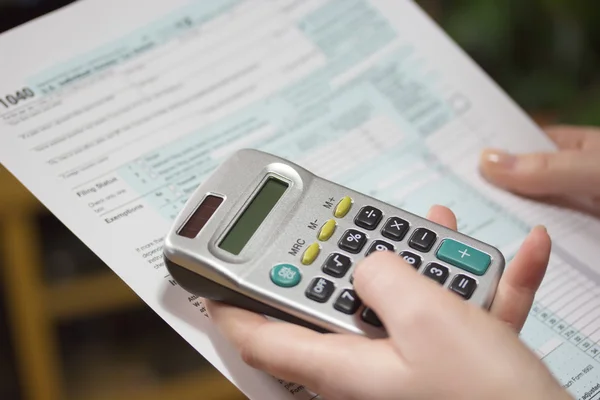 Invullen van formulieren van de inkomstenbelasting met calculator — Stockfoto