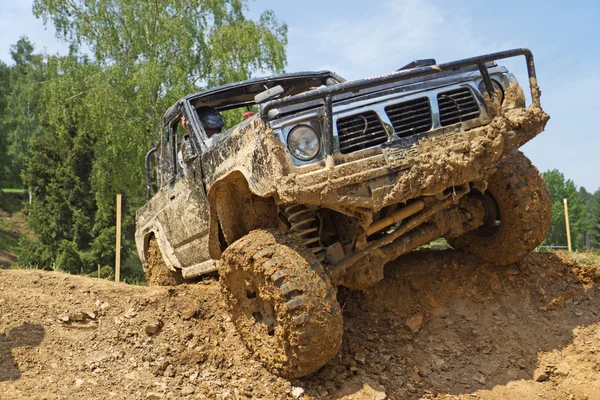 SUV overcomes steep muddy slope. — Stock Photo, Image