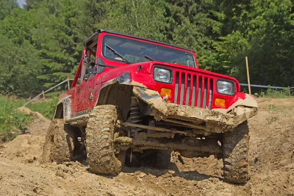 Roter Geländewagen im schlammigen Gelände. — Stockfoto