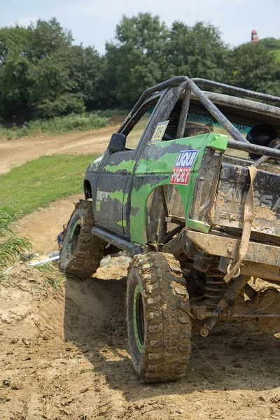 Green off-road car on a steep slope — Stock Photo, Image