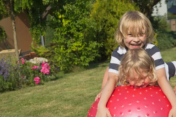 Blond boys are playing with gymnastic ball — Stock Photo, Image