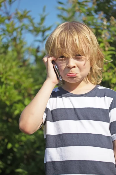 Annoyed blond boy is calling outdoors. — Stock Photo, Image