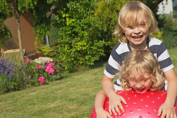 Two blond boys are playing with gymnastic ball — Stock Photo, Image