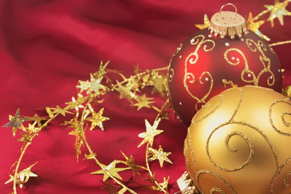 赤い背景の上の赤とゴールドのクリスマス用電球 — ストック写真