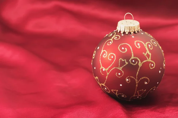 赤い背景の上の 1 つのクリスマス電球 — ストック写真