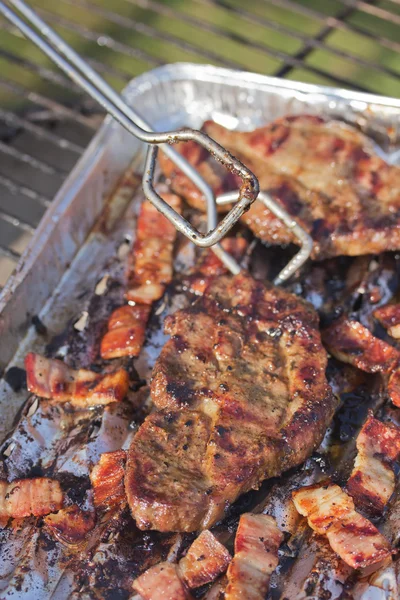 Turning grilled steak and bacon — Stock Photo, Image