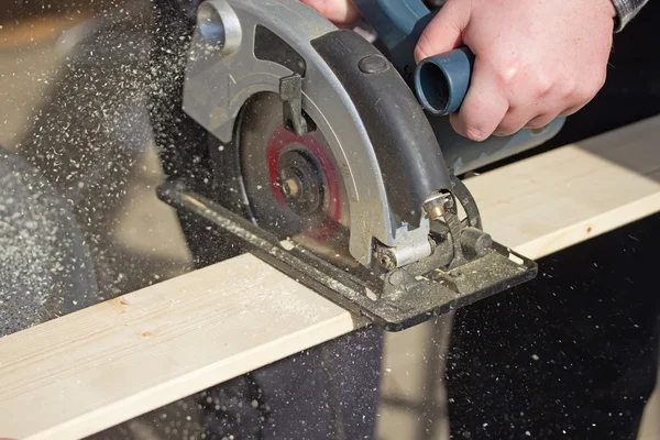 Man is working with electric circular saw — Stock Photo, Image