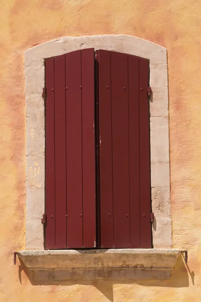 Close-up άποψη των παλαιών παραθύρων με τα κόκκινα ξύλινα παραθυρόφυλλα. — Φωτογραφία Αρχείου