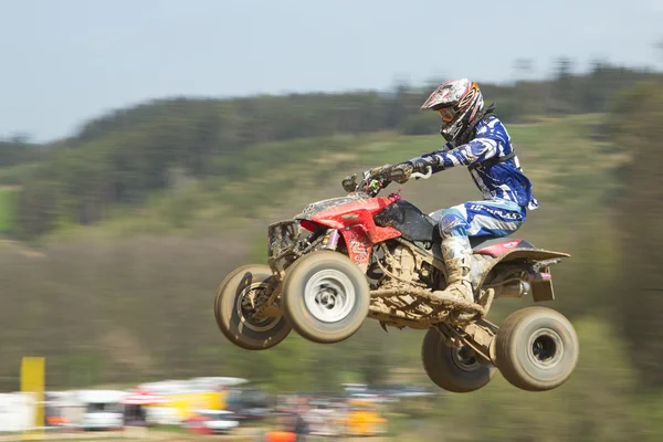 Quad racer in blue is jumping — Stock Photo, Image