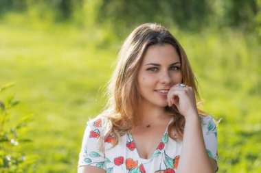 Çekici, genç bir bayan dışarıda poz veriyor. Yatay olarak. 