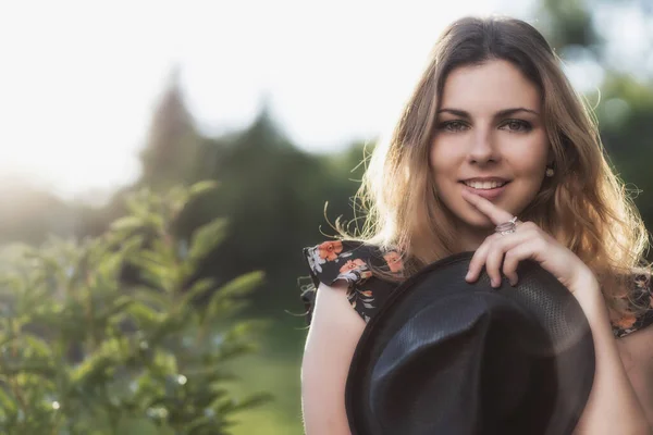 Retrato Mulher Jovem Atraente Segurando Chapéu Palha Preta Posando Livre — Fotografia de Stock