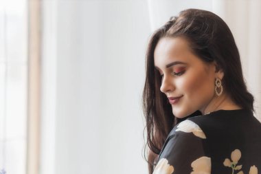 Çekici, gülümseyen bir kızın yan görünüm portresi. Gözleri kapalı, kapalı. Yatay olarak. 