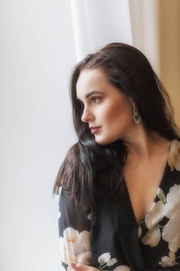 Çekici, koyu renk saçlı bir kızın yan görünümü. Dikey. 