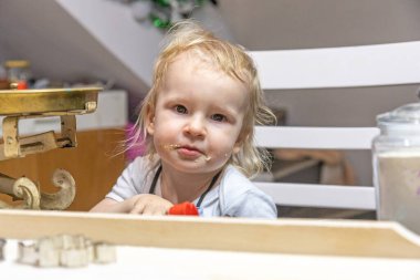 Kurabiye tatmaktan ağzı kirlenmiş poz veren sevimli bir çocuğun portresi. Yatay olarak.