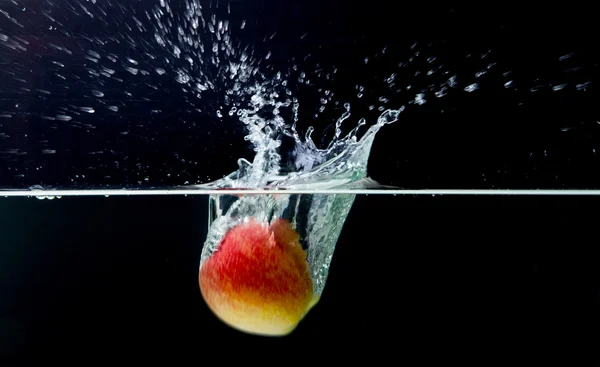 Red apple with splashing water — Stock Photo, Image