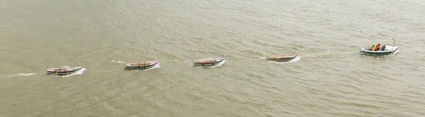 Motorboat dragging some rowing-boats — Stock Photo, Image