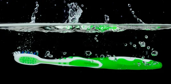 Cepillo de dientes con agua salpicada — Foto de Stock