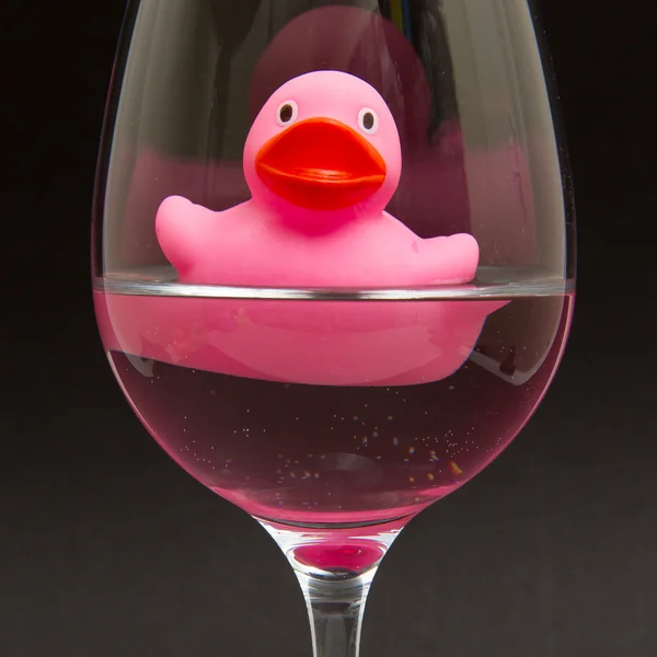 Pato de goma rosa en una copa de vino — Foto de Stock