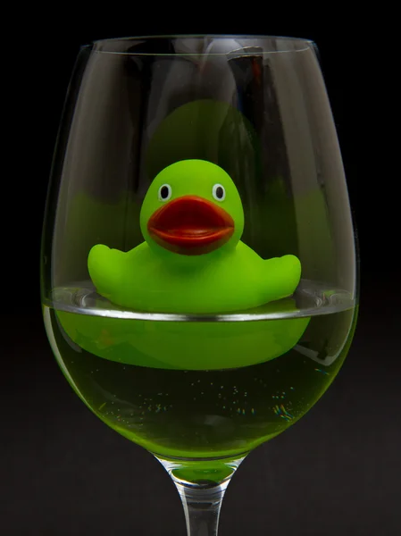 Pato de goma verde en una copa de vino — Foto de Stock