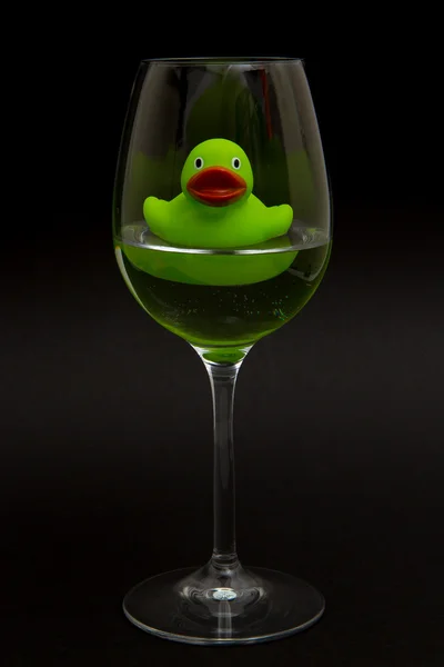 Pato de goma verde en una copa de vino — Foto de Stock