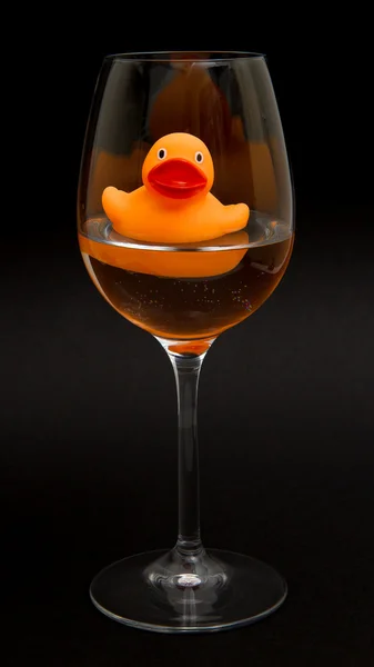 Pato de goma naranja en una copa de vino — Foto de Stock