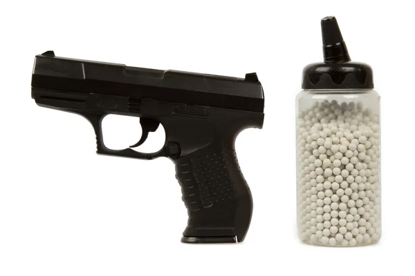 Balles blanches avec un pistolet noir (airsoft ) — Photo