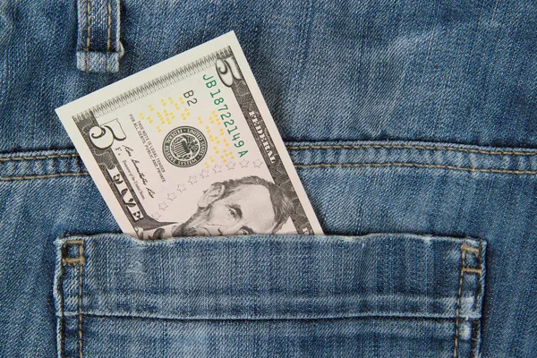 Macro tiro de jeans da moda com nota americana de 5 dólares — Fotografia de Stock