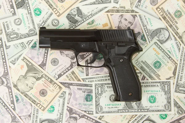 Pistolet noir isolé sur un tas d'argent — Photo
